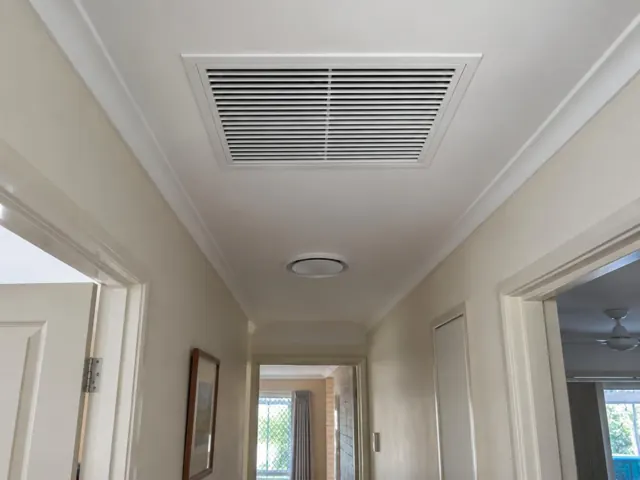 Ceiling return-air grille in a narrow hallway with doorways and painted walls in Nerang